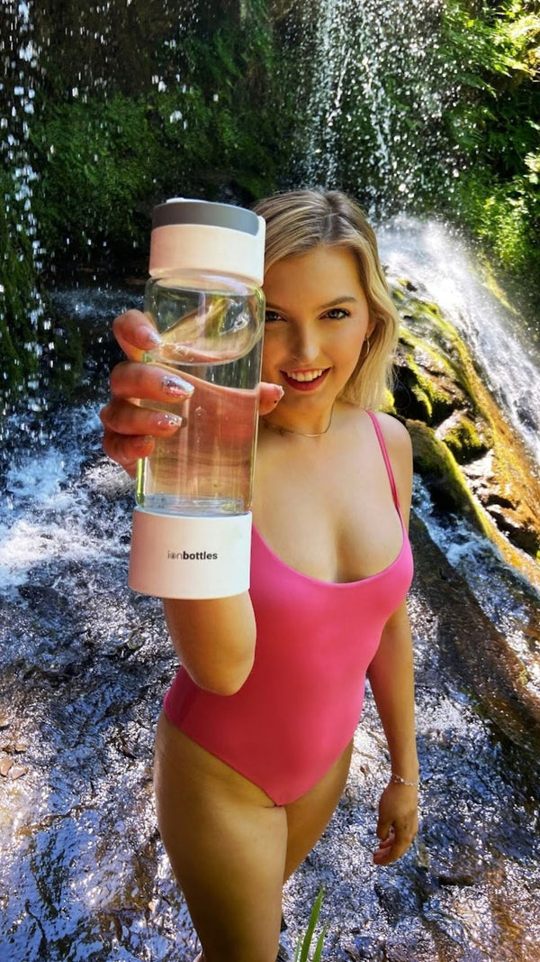 blonde in swimsuit holding ionbottles pro model hydrogen water bottle